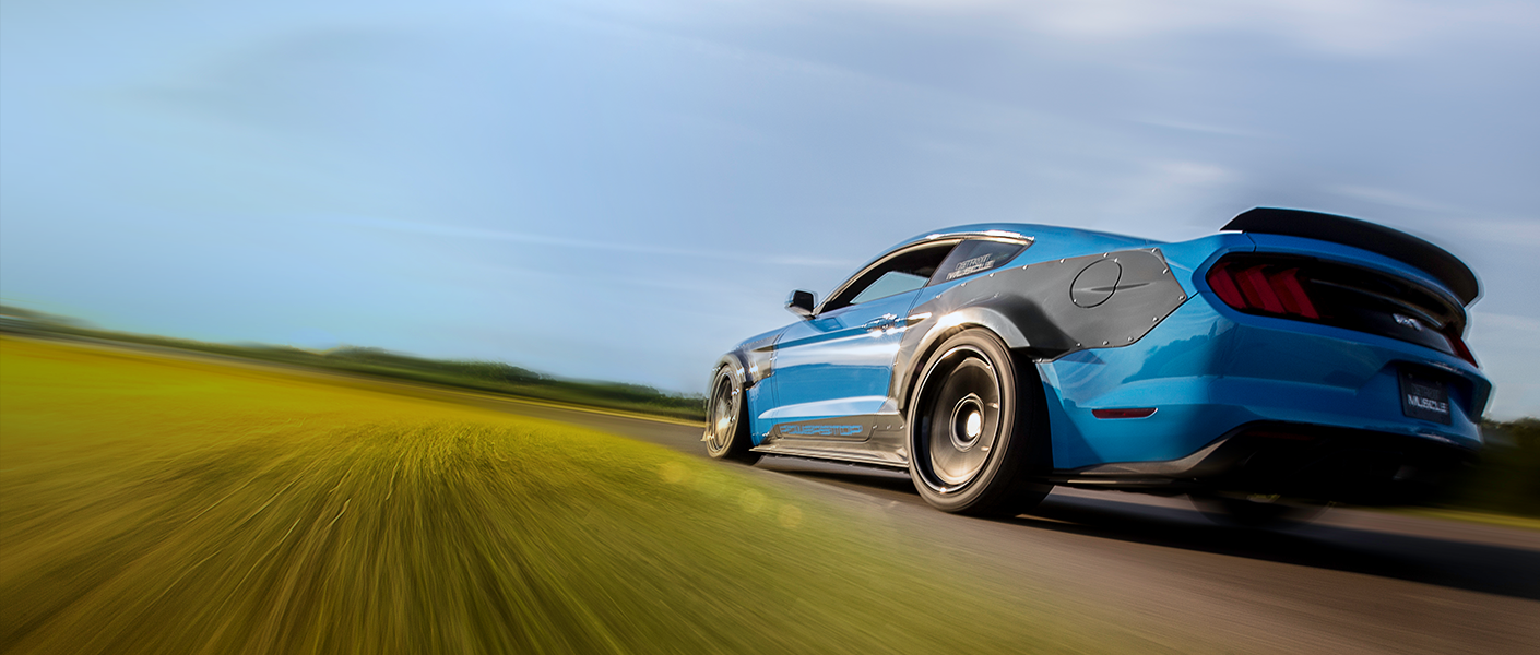 Blue Ford Mustang speeding along a road.