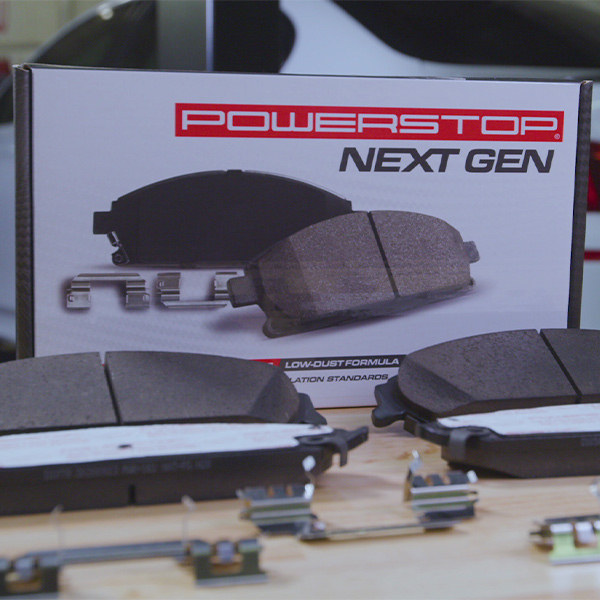 PowerStop Next Gen brake pads and hardware displayed on a wooden surface.