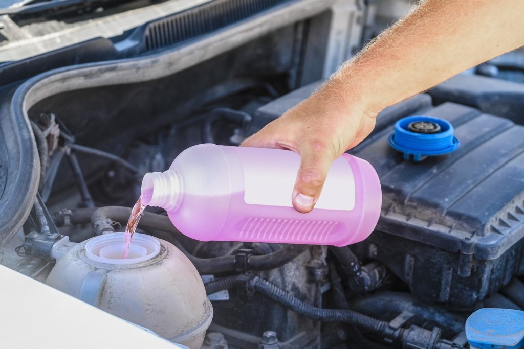 Coolant being poured into a car